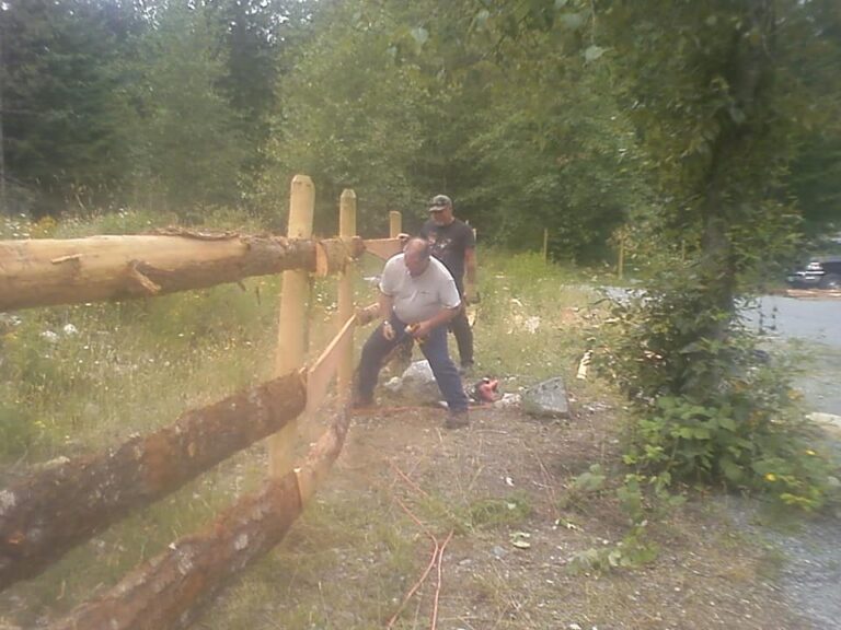 Volunteer building a split-rail fence in the forest
