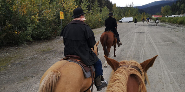Riders on horseback on a gravel road