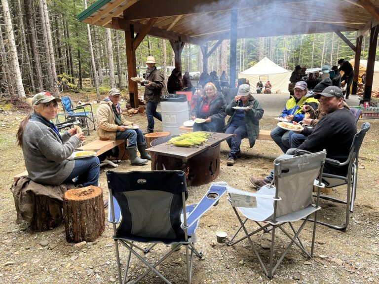 Robson Valley Chapter members around a campfire under a picnic shelter