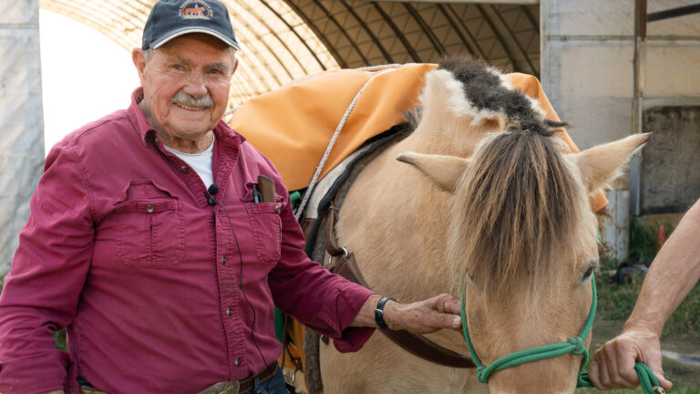 West Kootenay Chapter member with a palomino horse in a barn