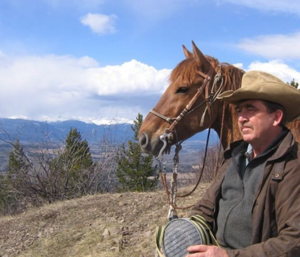 Eric Becker, BCHBC Vice President, with a horse in the mountains