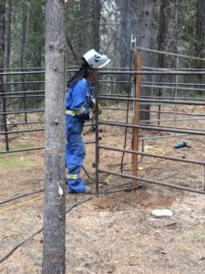 Volunteer welding a horse pen at Trapping Creek camp