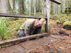 Volunteer building a wooden trail structure on the Pickles Road Trail