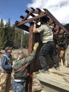 Volunteers assembling a timber trailhead kiosk